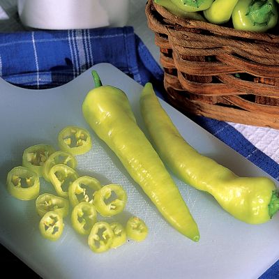 6-inch tapering fruits mature from green to yellow and eventually to scarlet, with a banana-like shape.